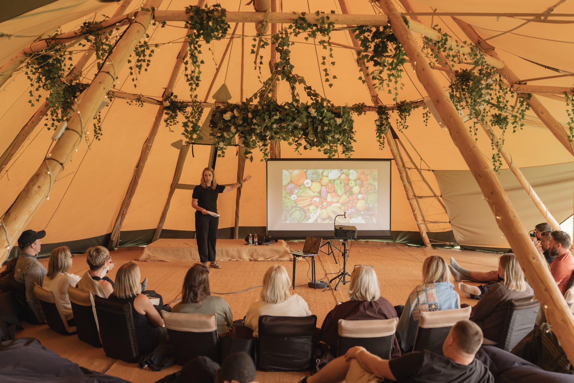 A workshop inside the tipi with guests seated around the speaker