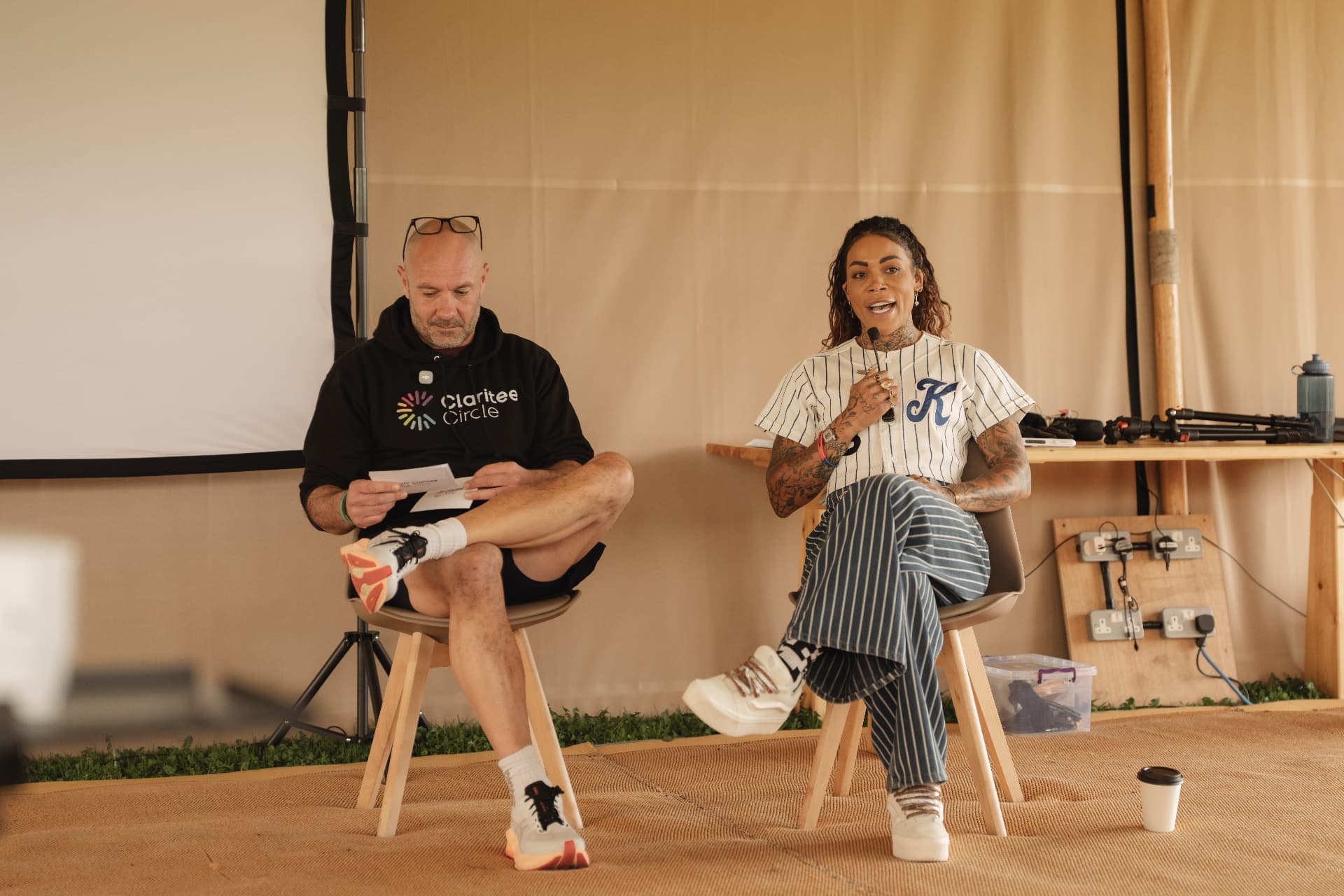 Two speakers in conversation on stage in the tent